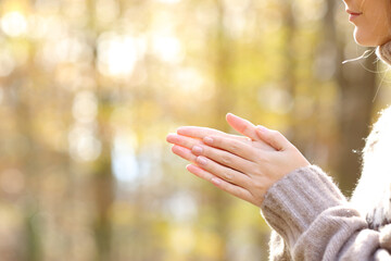 Woman rubbing and heatting hands in a cold autumn - obrazy, fototapety, plakaty