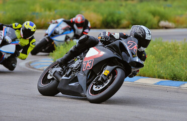 Motorcycle practice leaning into a fast corner on track