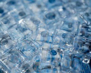 Selective focus, blurred background. Top above overhead close up macro view photo of ice cubes and water drops on blue background. High quality photo