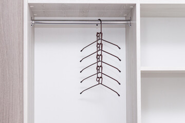 Empty metal multifunctional clothes hanger in empty wardrobe.