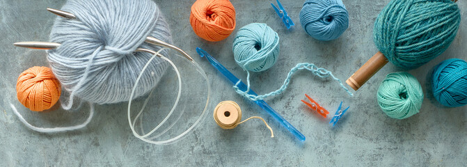 Various wool yarn and knitting needles, creative knitting hobby. Panoramic background in pastel...