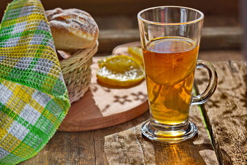 Chilled tea with lemon on a wooden table. Next on the kitchen breadboard with homemade cakes. Comfortably. House.Family.The concept of Good morning.