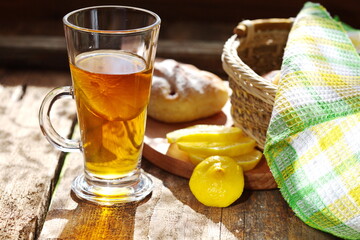 Chilled tea with lemon on a wooden table. Next on the kitchen breadboard with homemade cakes. Comfortably. House.Family.The concept of Good morning.