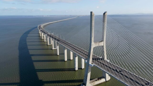 4k drone Aerial view of architectural landmark Vasco da Gama Bridge over the Tagus River at dusk in Lisbon, Portugal. The Vasco da Gama Bridge is the longest bridge in the European Union