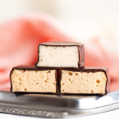 Chocolate souffle sweets or bird's milk on a white wooden table. Selective focus