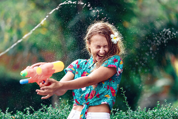 Caucasian young woman  fight with water gun in the Songkran festival. Holiday concept/ Thai new year