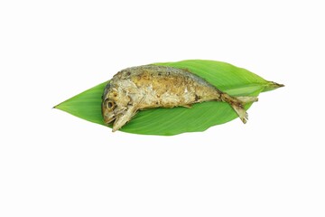 A fried mackerel on the green leaves.