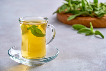 Cup of  hot sage tea with fresh leaves  , health concept, close up