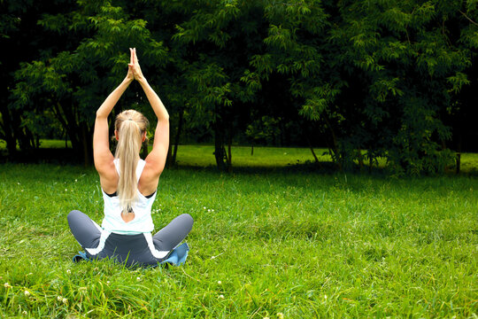 
Woman doing yoga exercises outdoors.
A beautiful sports girl is engaged in yoga on the background of beautiful nature.