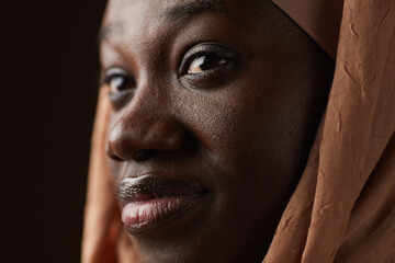 Extreme close up portrait of ethnic African-American woman wearing headscarf and looking away while...