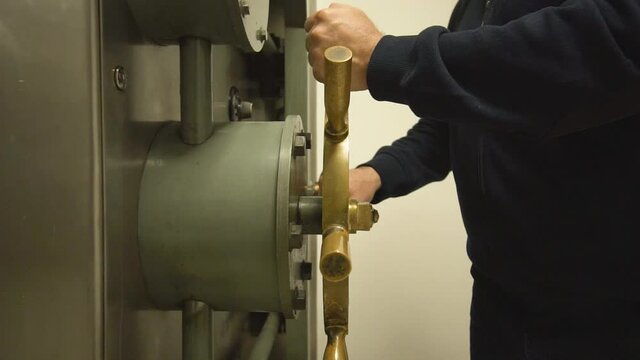close up man closes a big bank  safe door, safe money , heavy stainlees door banking accounts