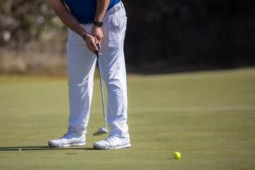 male golf player hitting the ball  wearing white shoes
