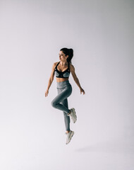 Fitness young woman jumping excited isolated on white background.