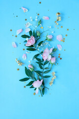 Creative layout made with pink and violet flowers on blue background. Flat lay.