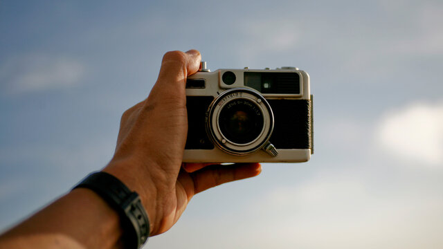 hand holding analog camera