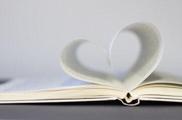Close-up of book pages folded into a heart shape. Love of reading.