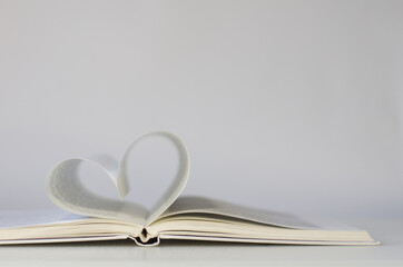 Close-up of book pages folded into a heart shape. Love of reading.