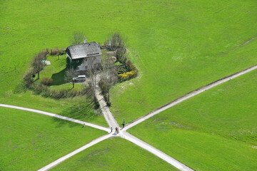 White house on a crossroads in a green meadow in Salzburg, Austria