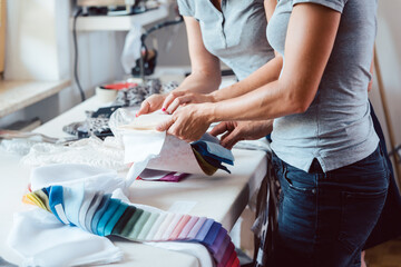 Fototapeta na wymiar Designers inspecting sample fabric in atelier