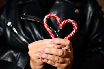 girl holding red heart made of Christmas candy