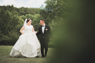 Happy wedding couple walking in a botanical park
