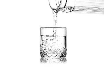Pouring of fresh water in glass on white background