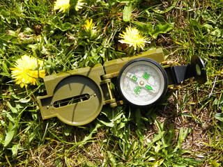 Compass on the meadow - travel and vacations concept.