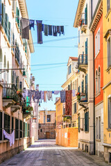 Fototapeta na wymiar narrow street in Venice, Venezia, Italy, laundry hung up to dry, sunshine, country customs