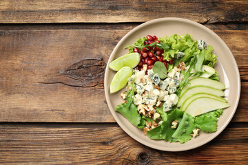 Fresh salad with pear on wooden table, top view. Space for text