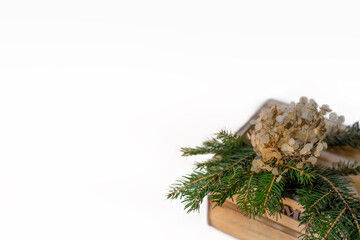 Christmas card background with natural decorations (wooden box with fir branches and flowers).