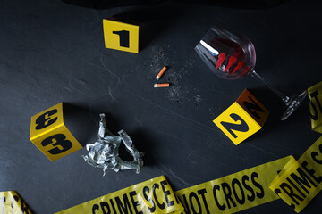 Flat lay composition with evidences and crime scene markers on black background