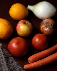 Still life of vegetables and fruits with tomato, onion, carrot, orange and apple