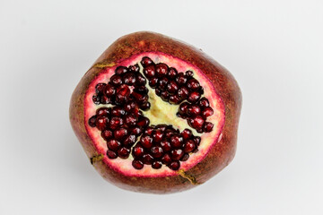 Cut off the top of the pomegranate fruit. Pomegranate fruit seeds are seen. A large red pomegranate...