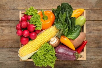 Different fresh vegetables on wooden table, top view