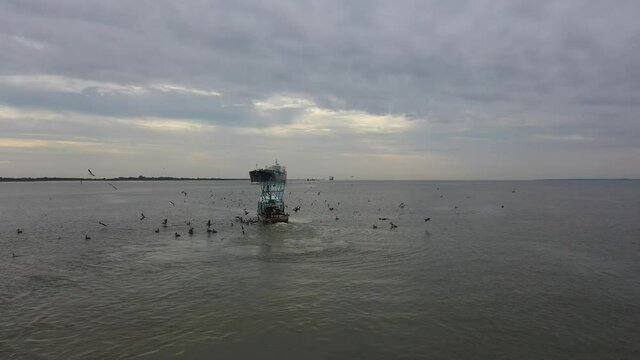 Merchant Ship Underway And Shrimp Boat Trawling