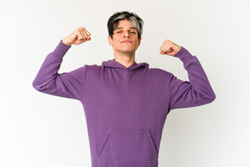 Young skinny hispanic man showing strength gesture with arms, symbol of power