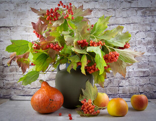 Autumn still life with red rowan, apples and pumpkin.