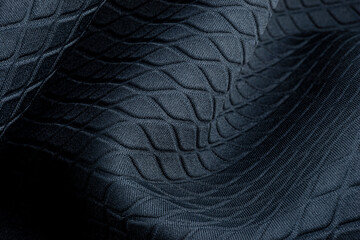 Background made from a macro of real material in dark blue, diamond shapes.
