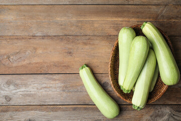 Ripe zucchinis on wooden table, flat lay. Space for text