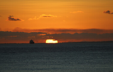 Fototapeta na wymiar fantastic sunset on the ocean horizon next to ship
