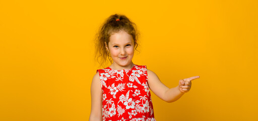 Energetic joyful adorable little girl laughing at joke on yellow background.