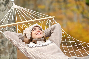 Happy woman in autumn relaxing on hammock