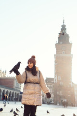 Fototapeta premium Young woman and pigeons in Market Square, Krakow, Poland