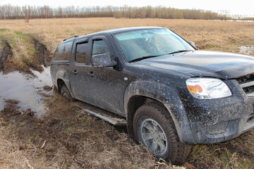 Plakat The black car got stuck in the mud. Off-road driving.