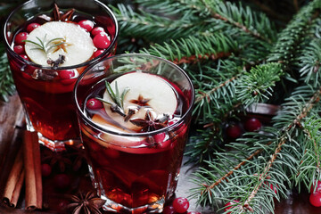 Mulled red wine with cranberry, apple and spices: anise, cinnamon, rosemary and cloves on dark...