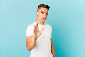 Young caucasian handsome man isolated rejecting someone showing a gesture of disgust.