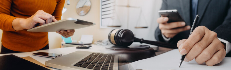 Business and lawyers discussing contract papers with brass scale on desk in office. Law, legal services, advice, justice and law concept picture with film grain effect
