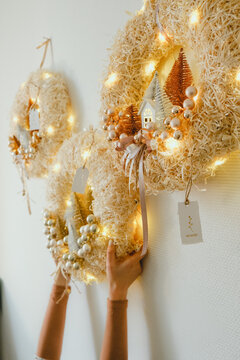 Three Handmade Christmas Wreath with Lights in Woman Hands for Winter holidays tradition, Lght garland, Natural and Ecofriendly Materials