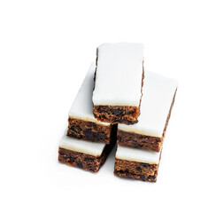 Fruit cake slices topped with marzipan isolated on white