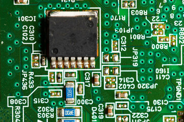 Electronic circuit close-up microchip on a green microcircuit with elements of transistors and strapping